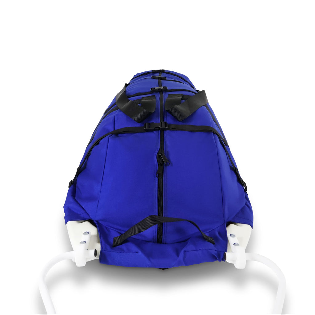 A blue snowmobile pulk sled cargo bag with black straps and a white plastic sled base, shown on a clean white background. A black label on the front displays the brand 'Wilderness Engineering'.