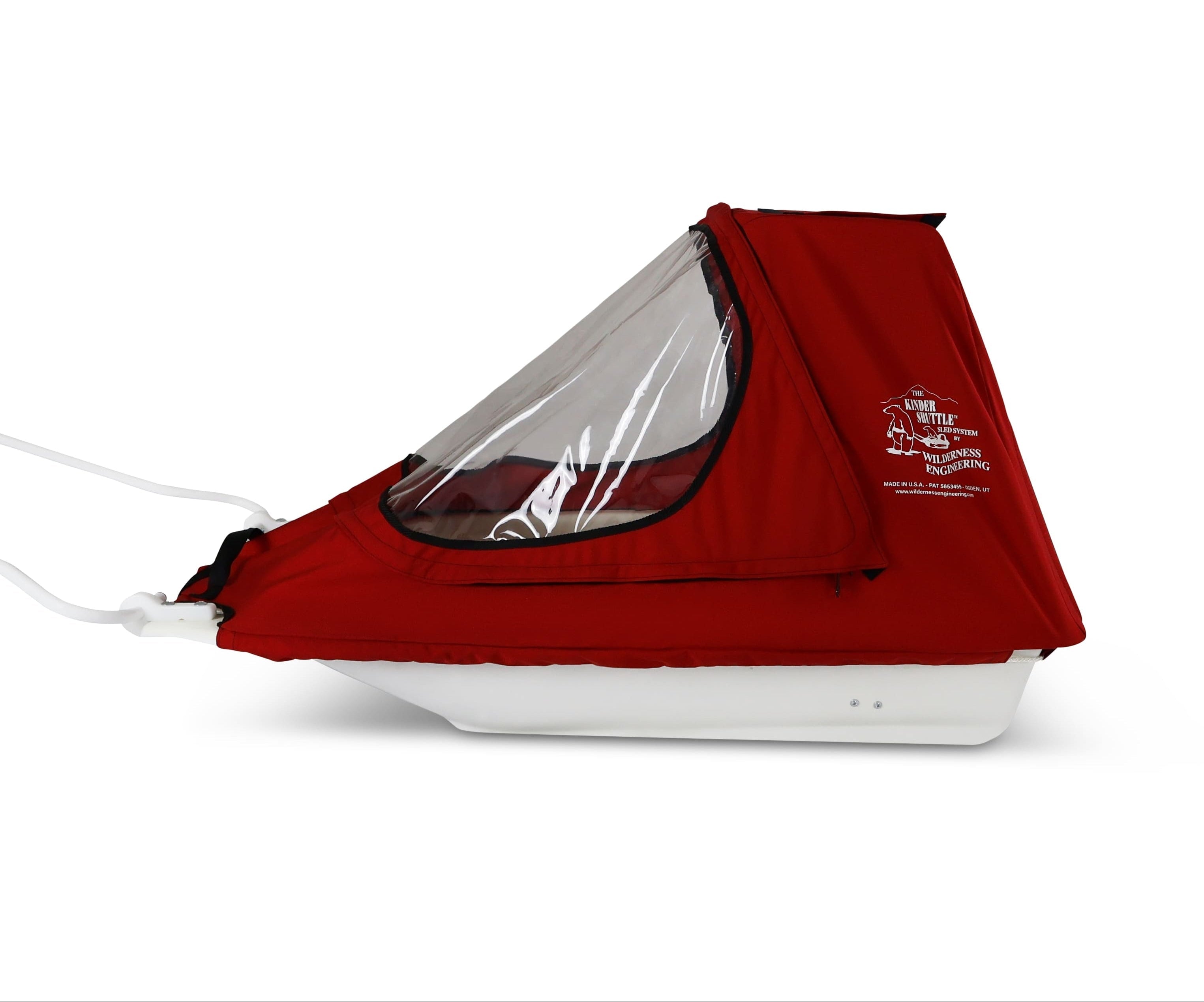 A red KinderShuttle Sled pulk with a clear plastic window and white sled, shown from the side on a white background.